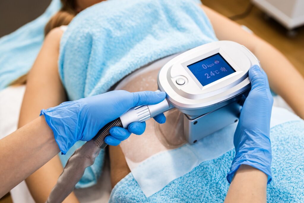 Close up of beautician therapist hands applying cryolipolysis treatment in beauty salon.