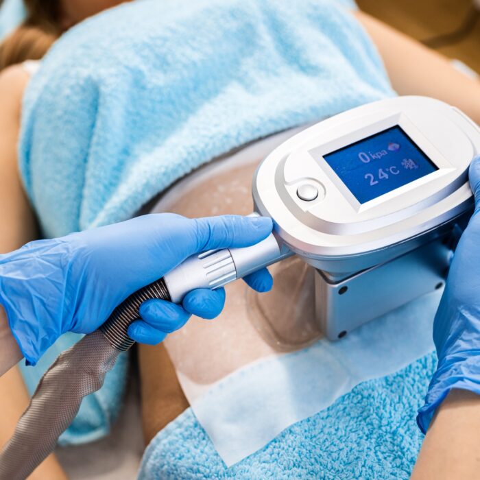 Close up of beautician therapist hands applying cryolipolysis treatment in beauty salon.