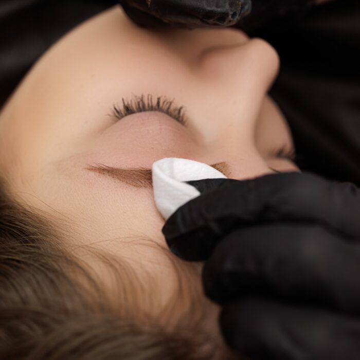 Close-up of the process of correction of permanent eyebrow makeup.