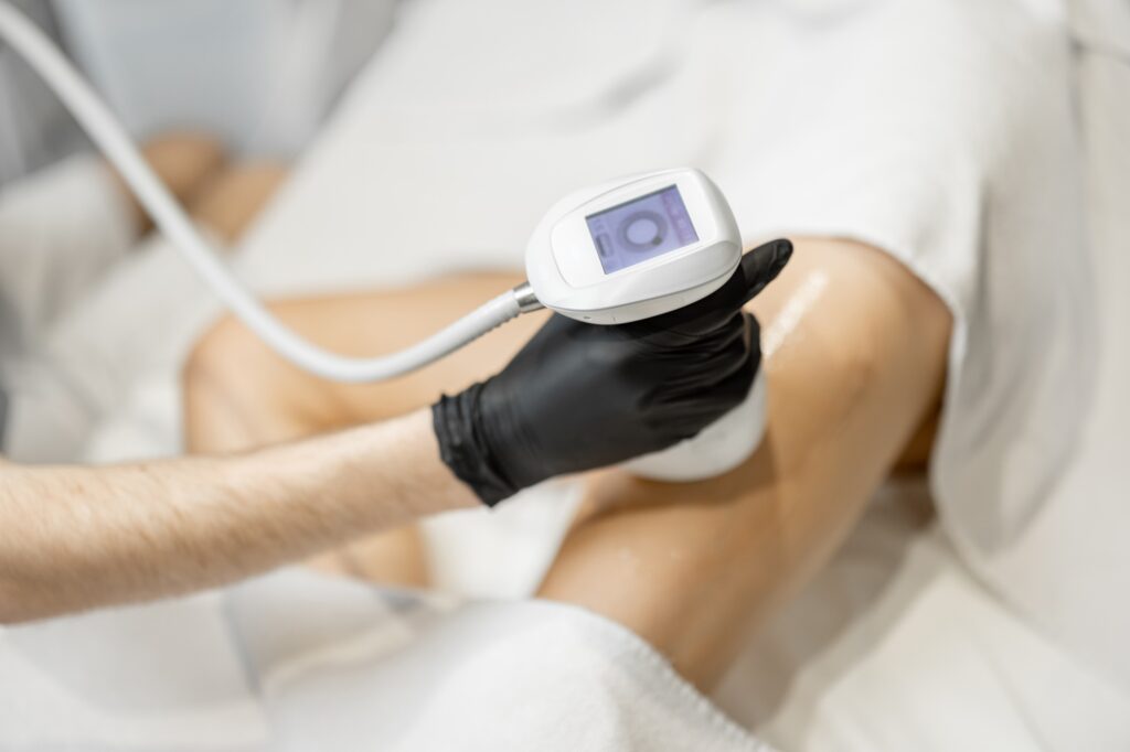 Doctor doing ultrasound liposuction procedure in medical clinic