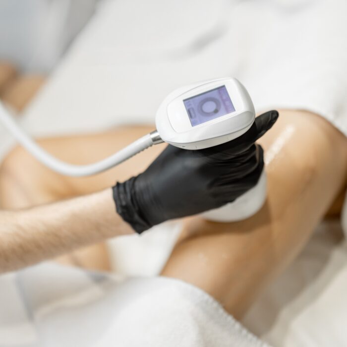 Doctor doing ultrasound liposuction procedure in medical clinic