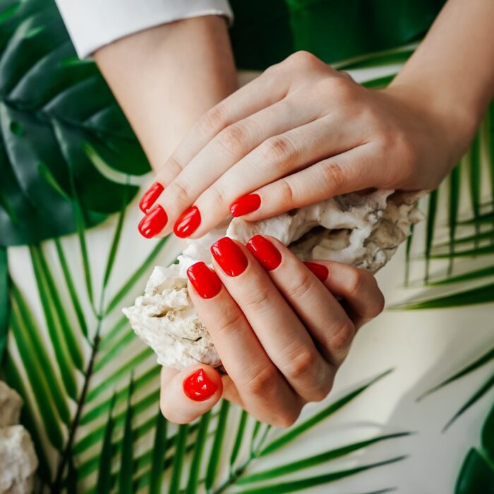 Manicured woman's nails with red nail polish.